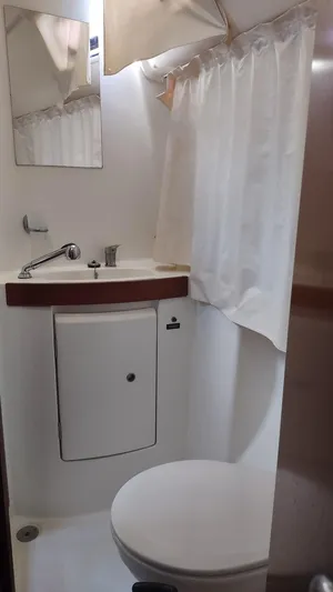 Tiffany Nicole Yacht Photos Pics Compact bathroom in 2011 Beneteau Oceanis 43 Family yacht with sink, mirror, and toilet.