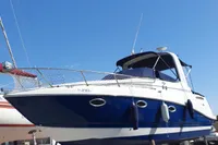 2008 Rinker 260 boat on dry dock under clear blue sky.