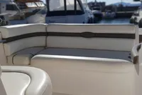 2008 Rinker 260 boat interior with white cushioned seating in a marina setting.