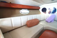 2008 Rinker 260 boat interior with beige seating and porthole window.
