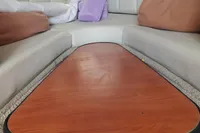 Interior seating area of a 2008 Rinker 260 boat with a wooden table.