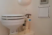 2008 Rinker 260 boat toilet with manual flush handle in compact bathroom setting.