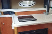 2008 Rinker 260 boat kitchenette with microwave, sink, and mini-fridge.