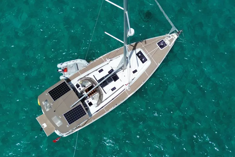 Lazy Days Yacht Photos Pics Aerial view of 2015 Jeanneau Sun Odyssey 469 sailboat on clear turquoise water.