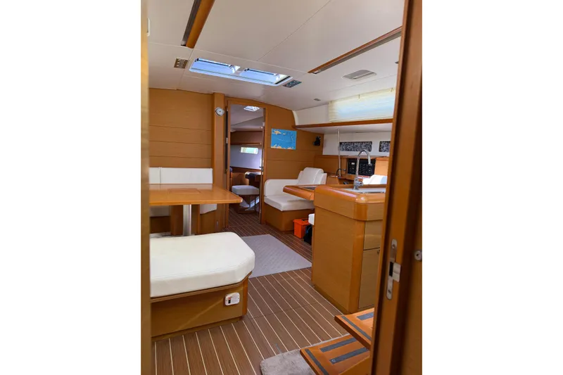 Lazy Days Yacht Photos Pics Interior of 2015 Jeanneau Sun Odyssey 469 sailboat, featuring modern wood finish and seating area.