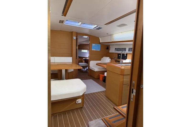 Lazy Days Yacht Photos Pics Interior of 2015 Jeanneau Sun Odyssey 469 yacht, featuring modern wood finish and seating area.
