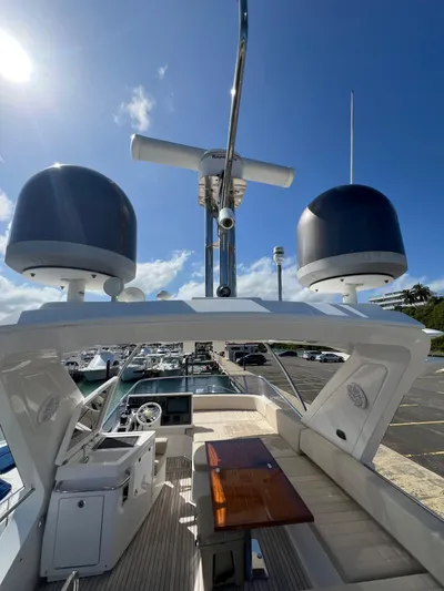 Lula Yacht Photos Pics 2016 Azimut 54fly yacht flybridge with radar domes and seating area under clear blue sky.