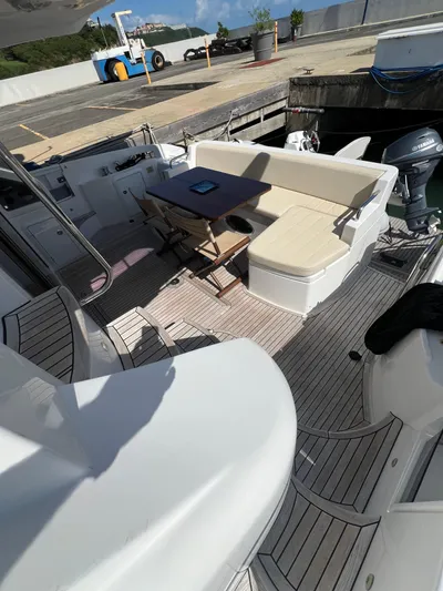 Lula Yacht Photos Pics 2016 Azimut 54fly yacht deck with seating and table, docked at marina.