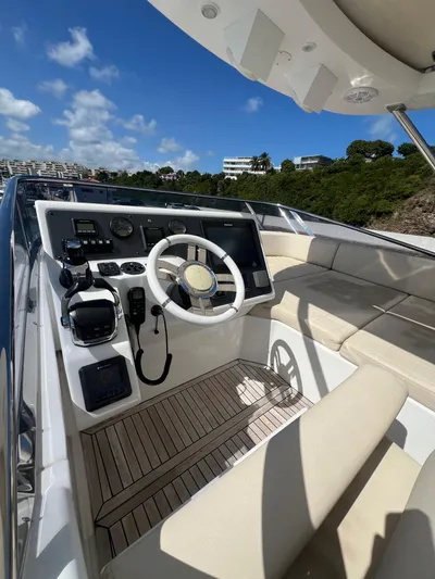 Lula Yacht Photos Pics 2016 Azimut 54fly yacht helm with modern controls and beige seating under blue sky.