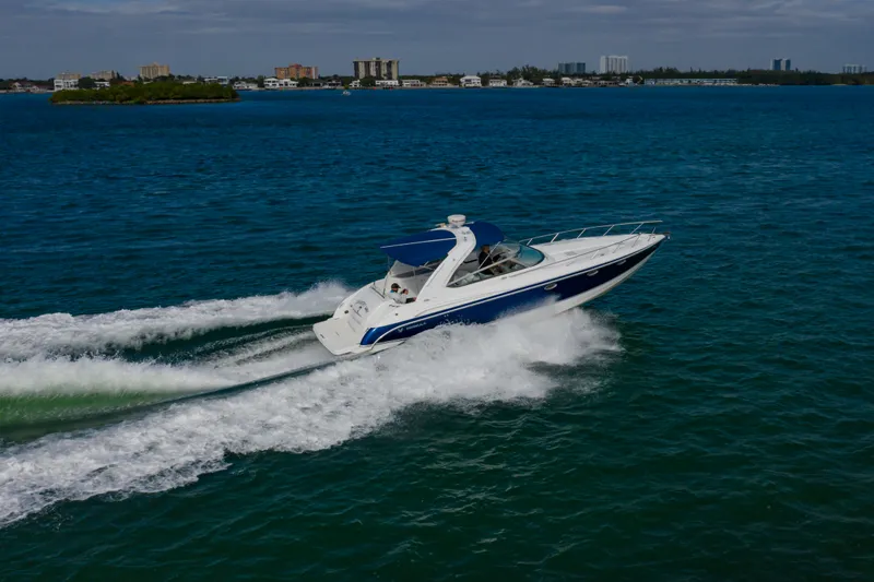 Carmita's Way Yacht Photos Pics 2007 Formula 370 Super Sport cruising on open water, cityscape in background.