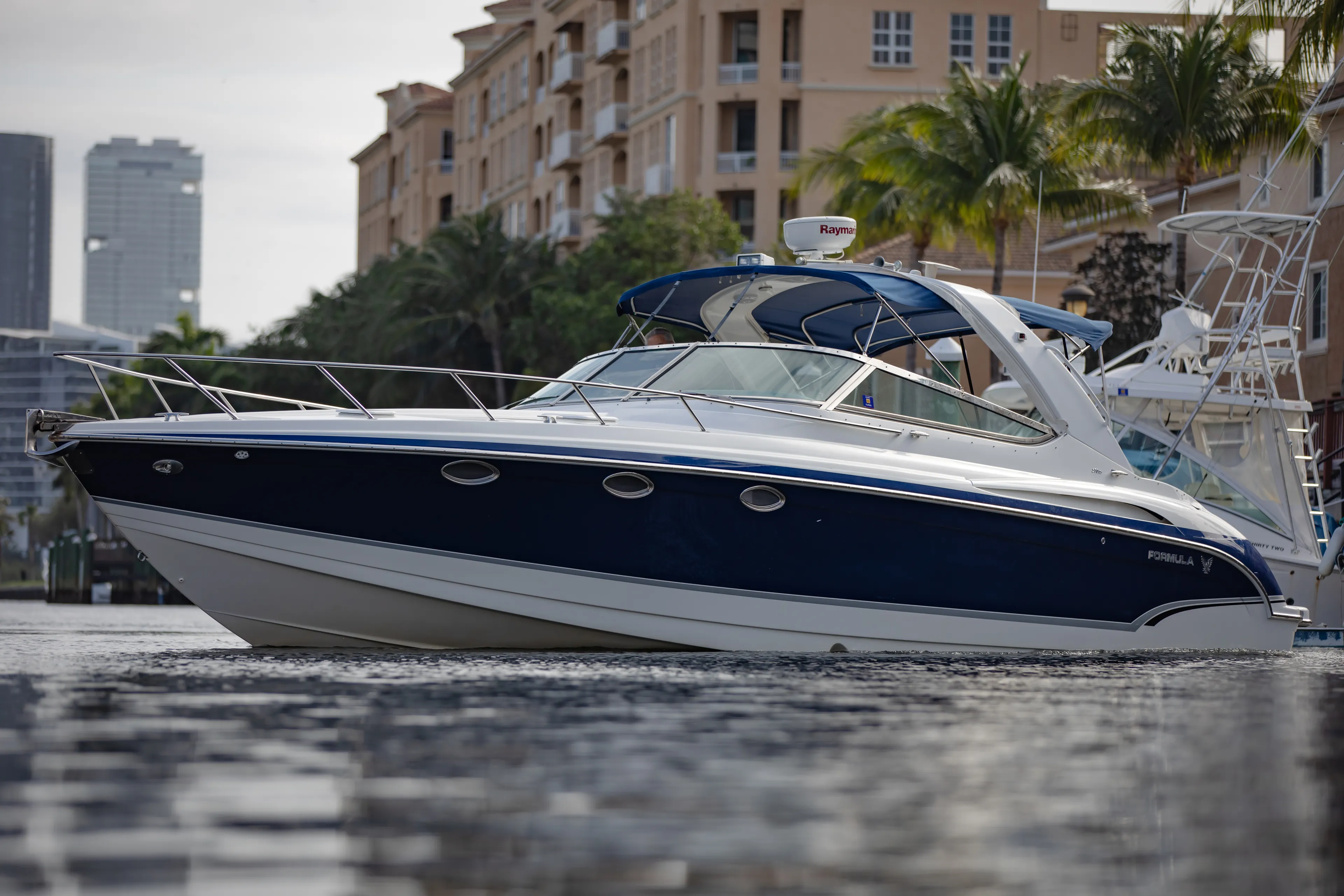 Carmita's Way Yacht Photos Pics 2007 Formula 370 Super Sport boat on water near city buildings and palm trees.