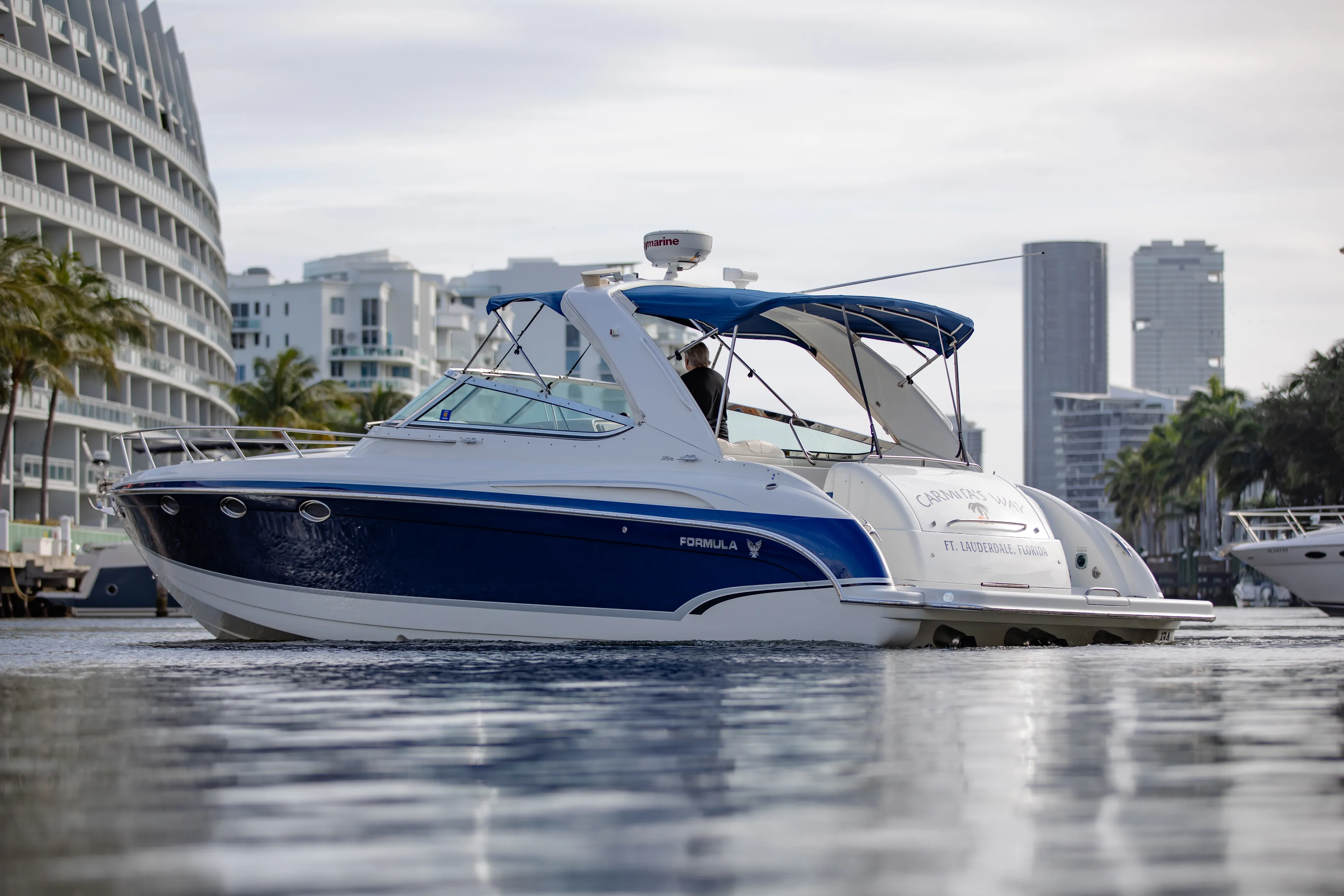 Carmita's Way Yacht Photos Pics 2007 Formula 370 Super Sport boat cruising near city waterfront.