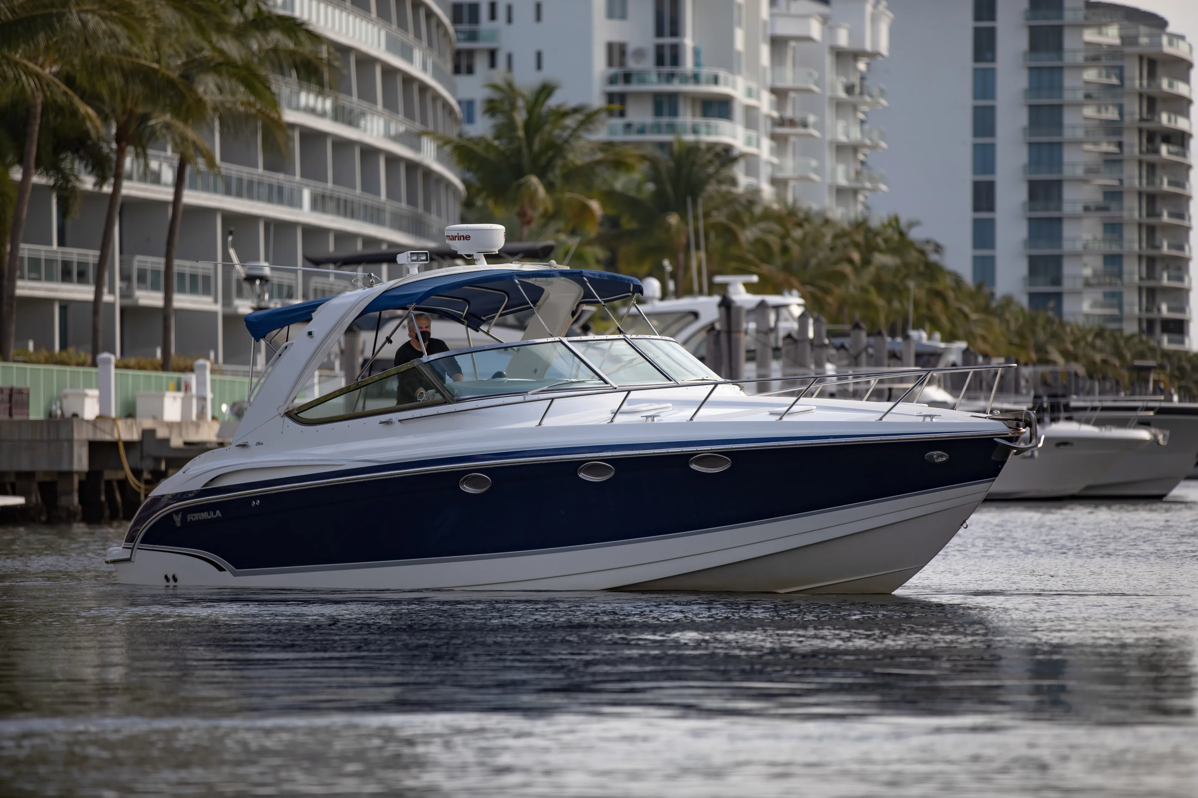 Carmita's Way Yacht Photos Pics 2007 Formula 370 Super Sport boat cruising near modern waterfront buildings.