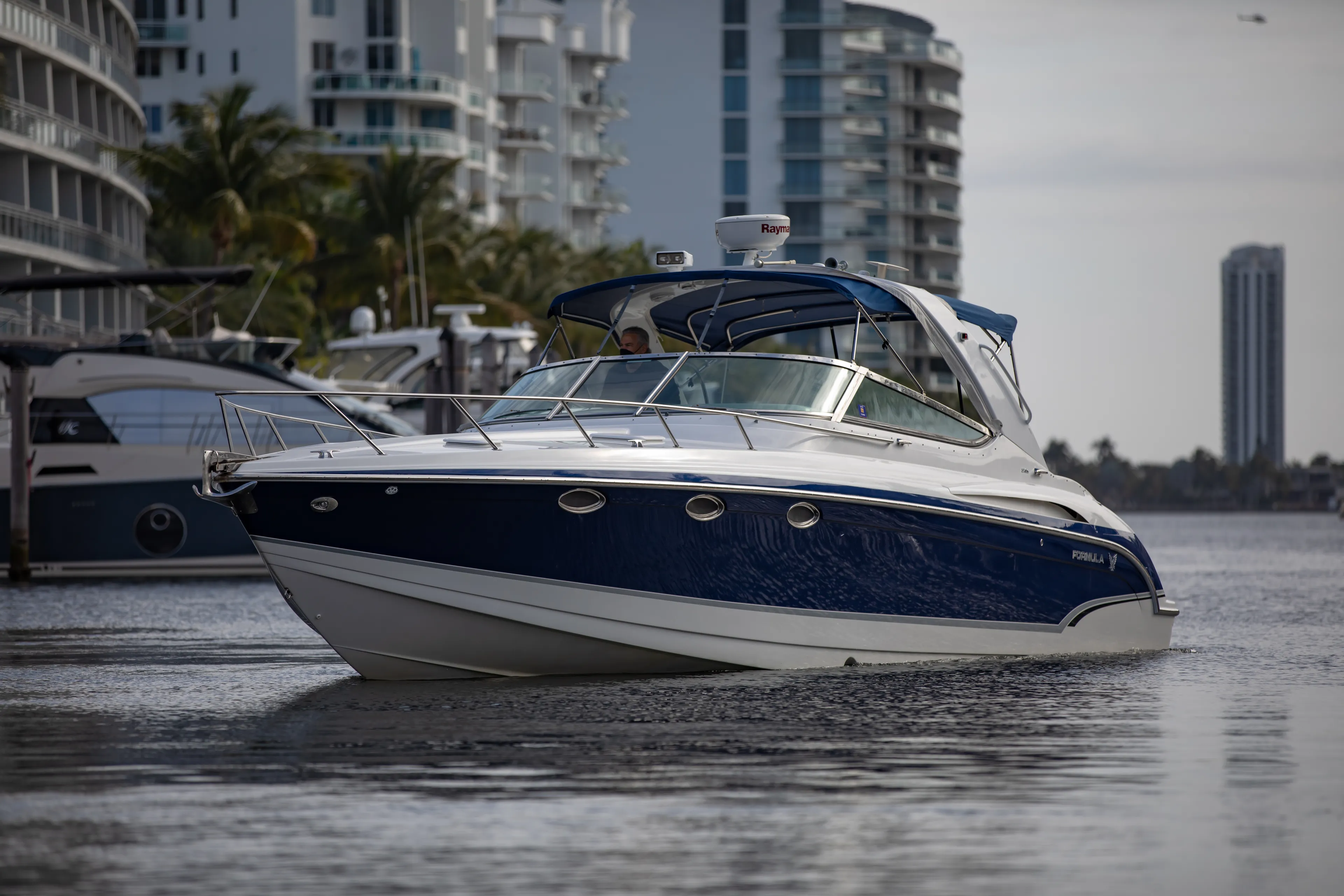 Carmita's Way Yacht Photos Pics 2007 Formula 370 Super Sport boat cruising near modern waterfront buildings.