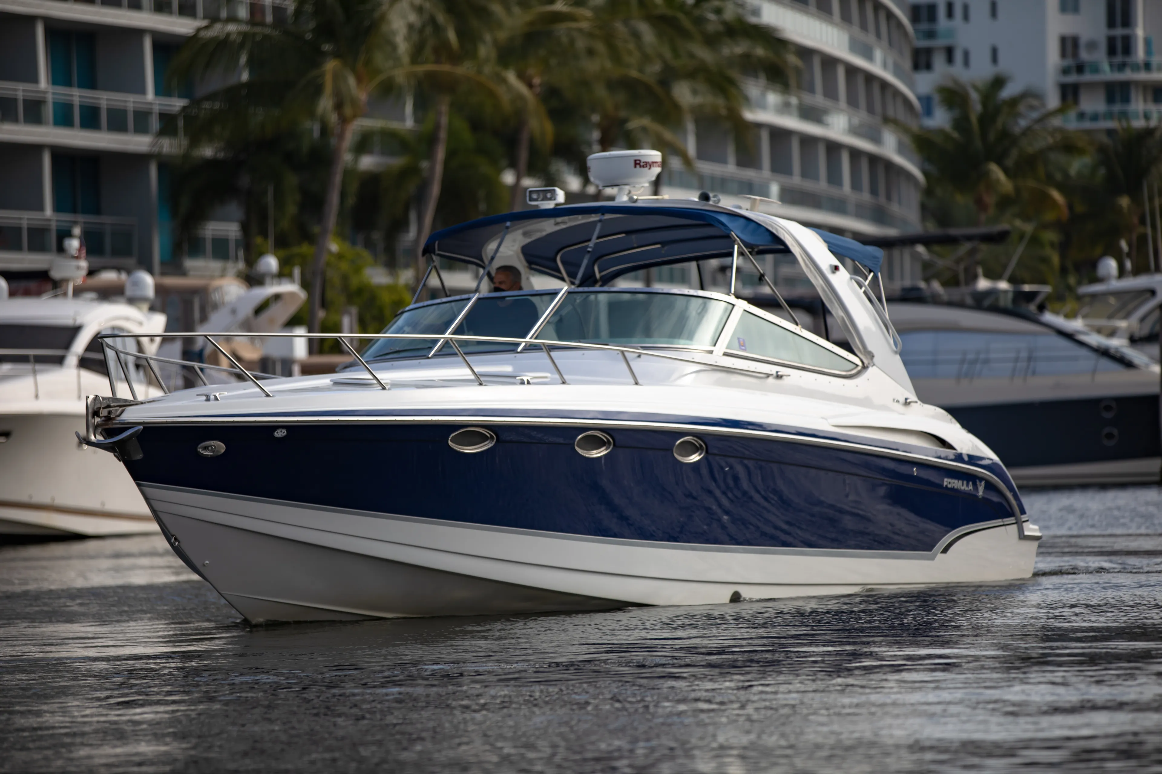Carmita's Way Yacht Photos Pics 2007 Formula 370 Super Sport boat on water, surrounded by palm trees and buildings.