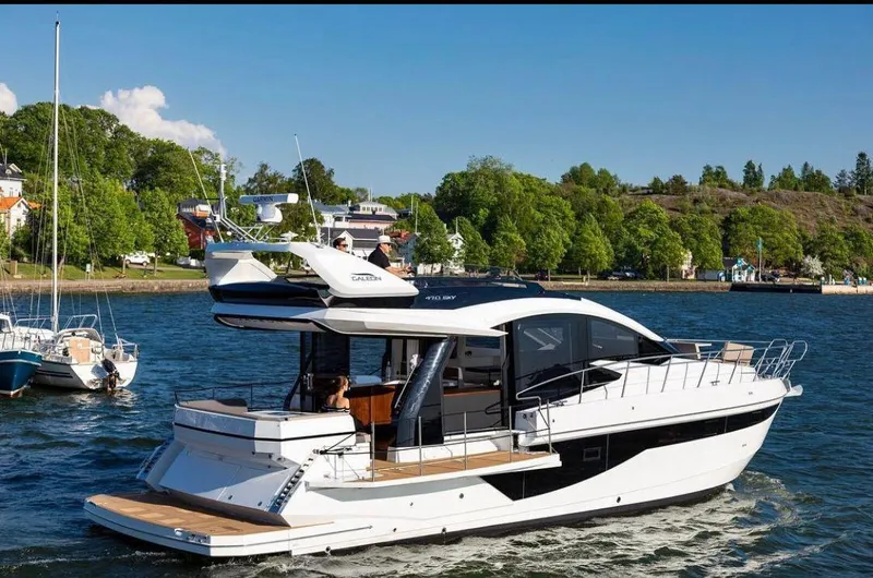  Yacht Photos Pics 2017 Galeon 500 Fly yacht cruising on a scenic lake with lush greenery.