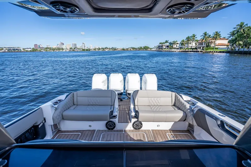 45-18 Yacht Photos Pics 2018 Nor-Tech 450 Sport boat with luxurious seating, overlooking a scenic waterfront view.