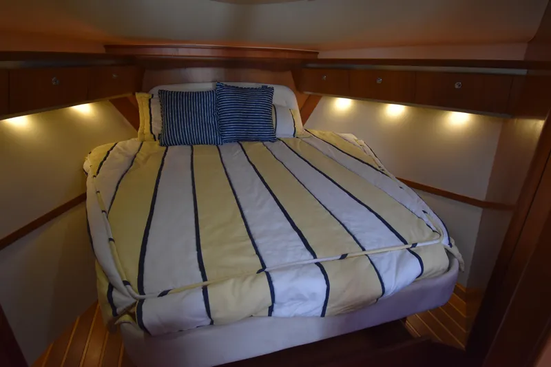 Bossa Nova Yacht Photos Pics Cozy cabin interior of 2006 Tiara Yachts 3600 Open with striped bedding and ambient lighting.