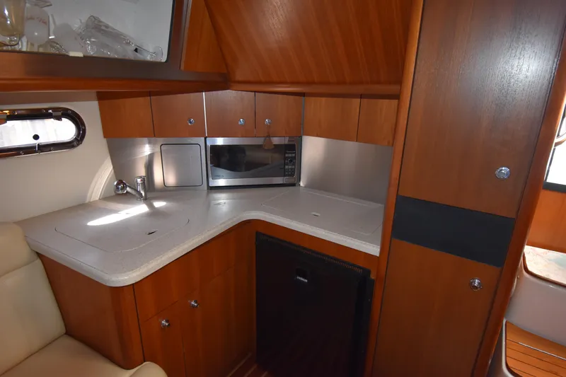 Bossa Nova Yacht Photos Pics 2006 Tiara Yachts 3600 Open galley with wood cabinetry, sink, microwave, and compact fridge.