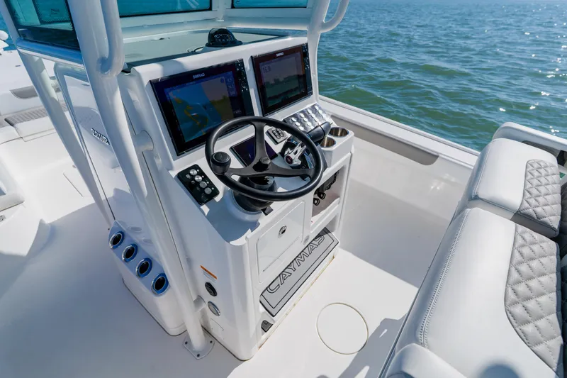  Yacht Photos Pics 2022 Caymas 28 HB boat helm with dual displays and steering wheel on open water.