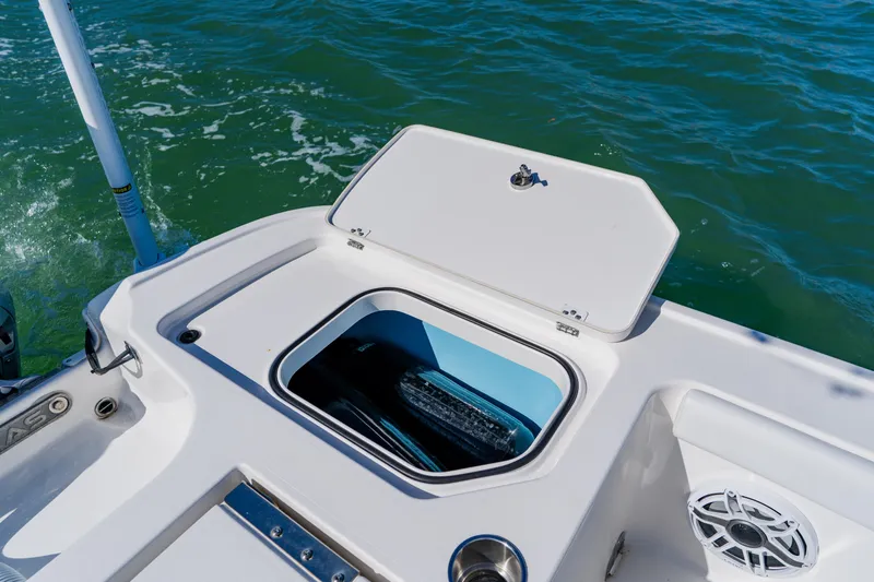  Yacht Photos Pics 2022 Caymas 28 HB boat with open storage compartment on deck, near water.