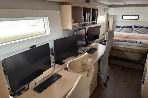 Tomcat Yacht Photos Pics Modern office setup inside 2023 Lagoon 46 yacht with multiple monitors and workspace.