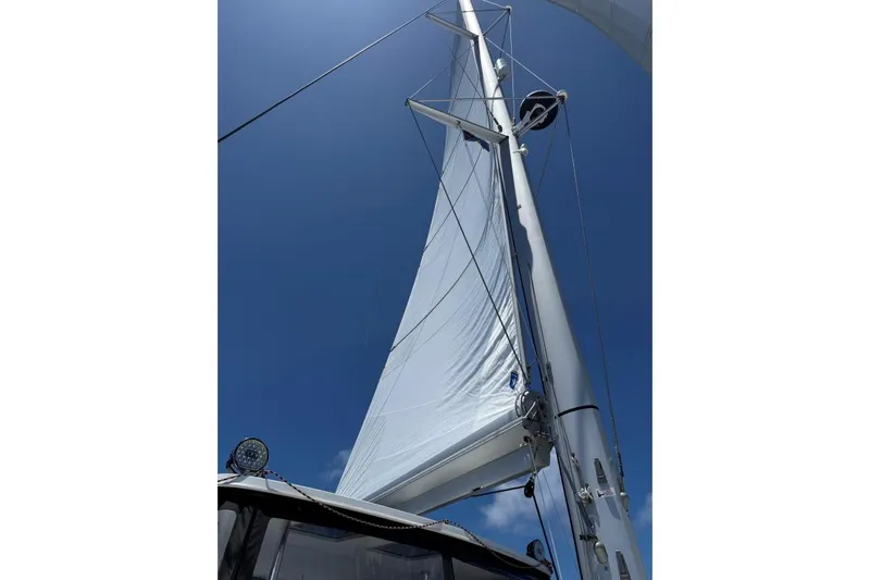 Tomcat Yacht Photos Pics Sailing mast and sail of 2023 Lagoon 46 catamaran against clear blue sky.
