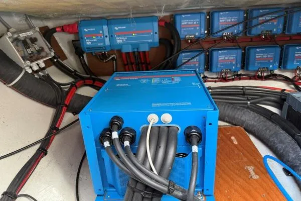 Tomcat Yacht Photos Pics Electrical system setup in a 2023 Lagoon 46 yacht, featuring blue power units and cables.