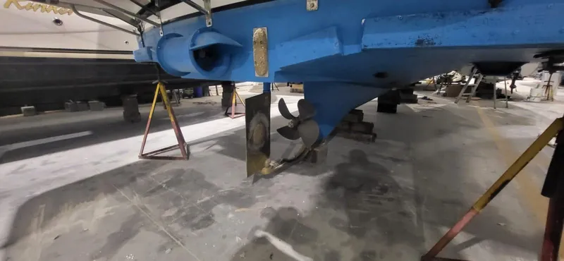  Yacht Photos Pics 2022 Legacy 36 boat under maintenance, showcasing propeller and hull in a workshop setting.