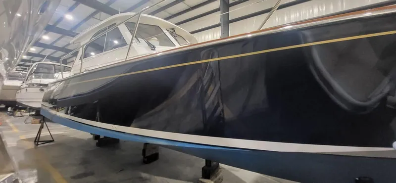  Yacht Photos Pics 2022 Legacy 36 yacht in storage, sleek design, dark hull, indoor facility.