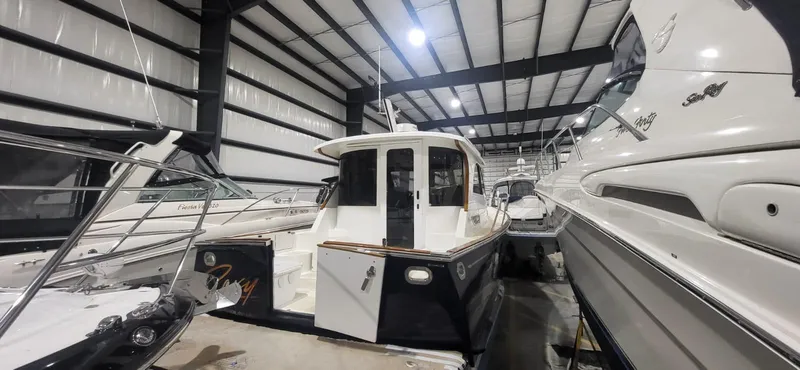  Yacht Photos Pics 2022 Legacy 36 yacht in storage, surrounded by other boats in a spacious indoor facility.