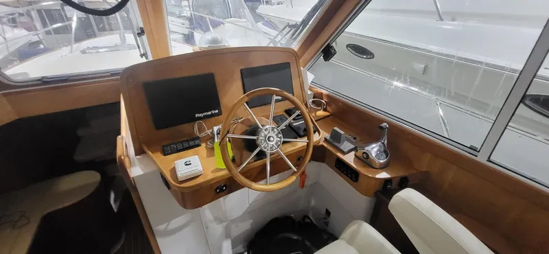  Yacht Photos Pics 2022 Legacy 36 Legacy boat cockpit with steering wheel and navigation equipment.