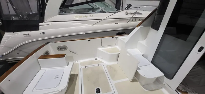  Yacht Photos Pics 2022 Legacy 36 boat interior with seating and storage, docked beside another vessel.