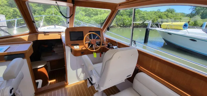  Yacht Photos Pics Interior view of 2022 Legacy 36 boat with wooden accents and steering wheel.