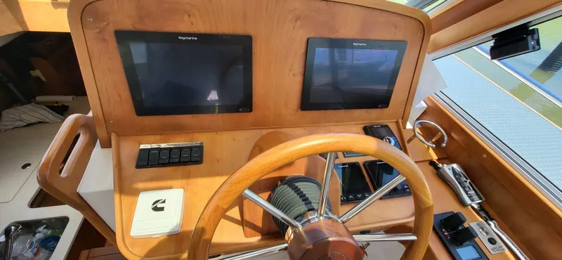  Yacht Photos Pics 2022 Legacy 36 boat helm with dual Raymarine displays and wooden steering wheel.