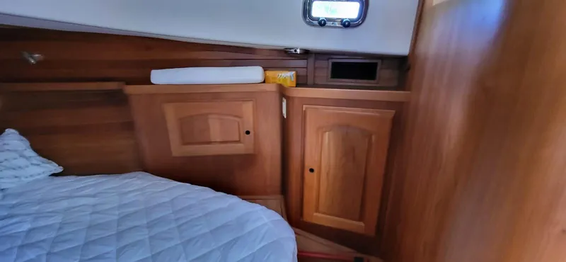  Yacht Photos Pics Cozy cabin interior of 2022 Legacy 36 yacht with wooden cabinetry and bedding.