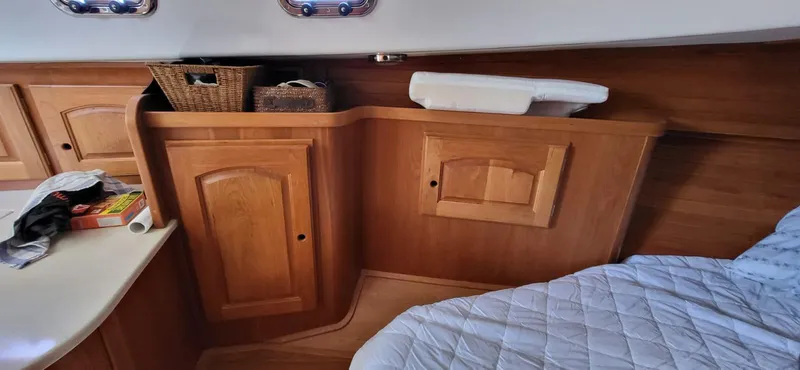  Yacht Photos Pics Interior of 2022 Legacy 36 boat with wooden cabinets and a cozy bed.
