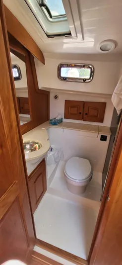  Yacht Photos Pics 2022 Legacy 36 yacht bathroom with wooden cabinets and skylight.
