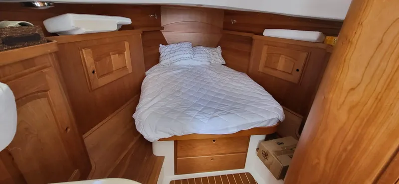  Yacht Photos Pics Cozy cabin interior of 2022 Legacy 36 boat with wooden finish and comfortable bedding.