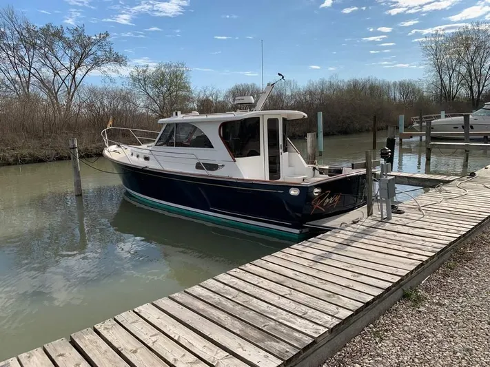  Yacht Photos Pics 2022 Legacy 36 boat docked on a calm river with wooden pier.