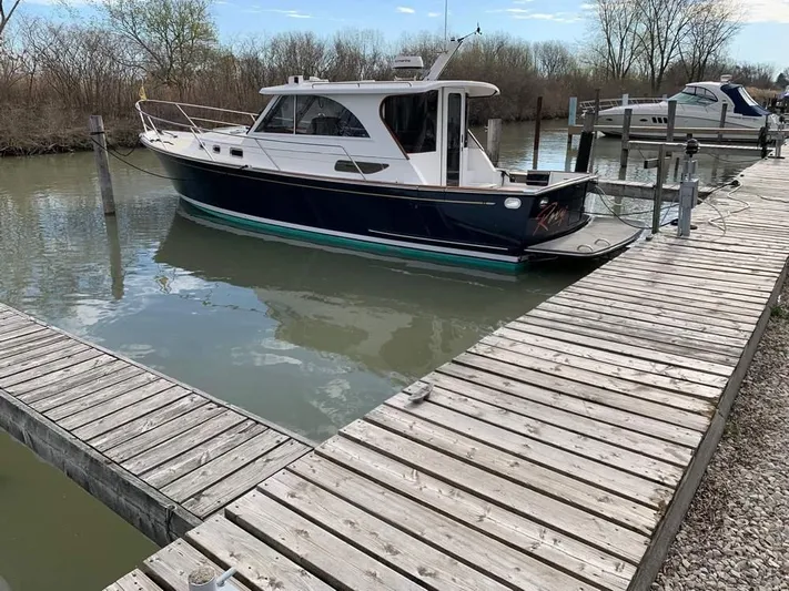  Yacht Photos Pics 2022 Legacy 36 boat docked at a marina with wooden walkways.