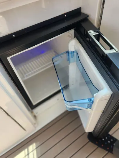  Yacht Photos Pics Open mini fridge on 2004 Sea Ray Sundancer 460 yacht, showing interior shelves.