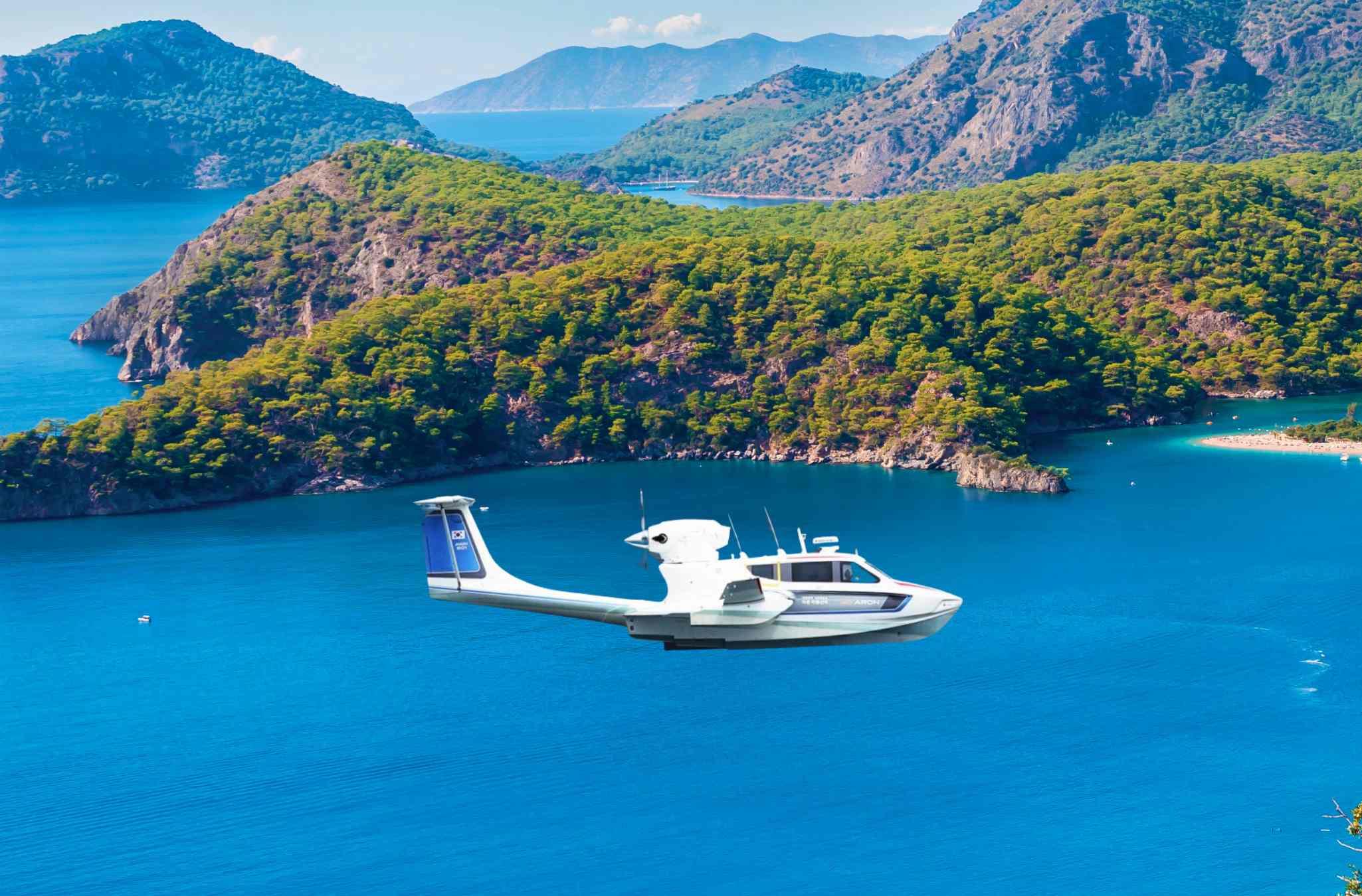 Seaplane Aron M 80 (2025) flying over scenic coastal landscape with lush green islands.