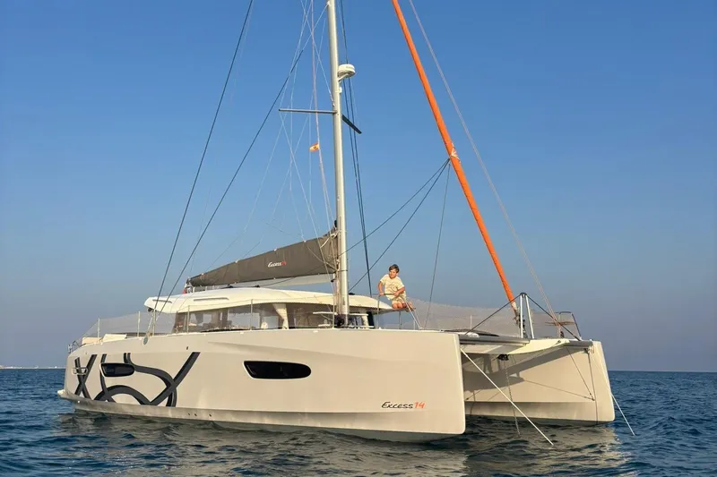  Yacht Photos Pics 2025 Excess 14 catamaran sailing on calm sea under clear blue sky.