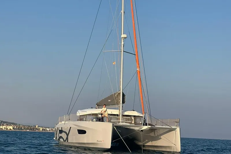  Yacht Photos Pics 2025 Excess 14 catamaran sailing on calm sea under clear blue sky.