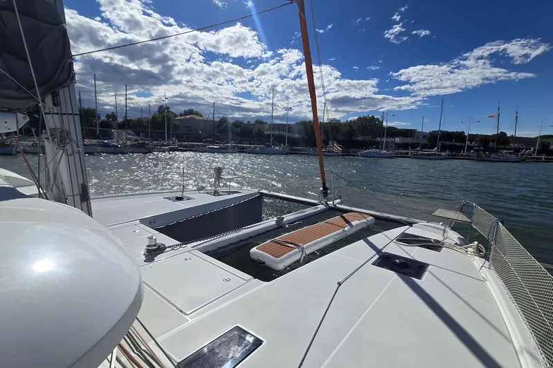  Yacht Photos Pics 2025 Excess 14 catamaran docked in a sunny marina, showcasing sleek design and spacious deck.