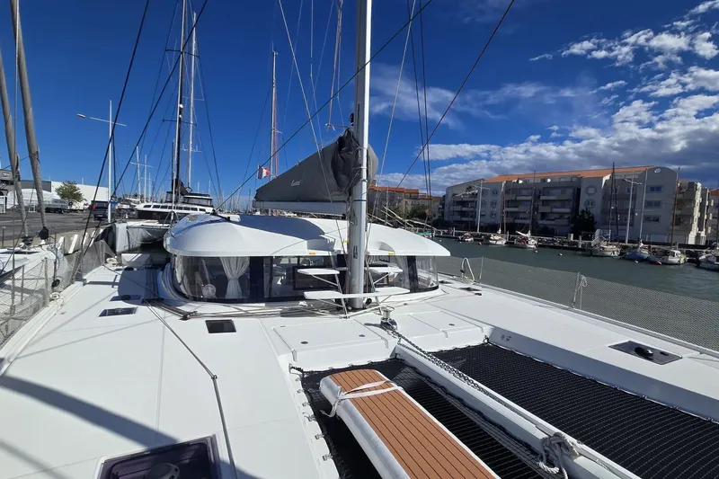  Yacht Photos Pics Sailing catamaran Excess 14, 2025 model, docked in a marina under a clear blue sky.
