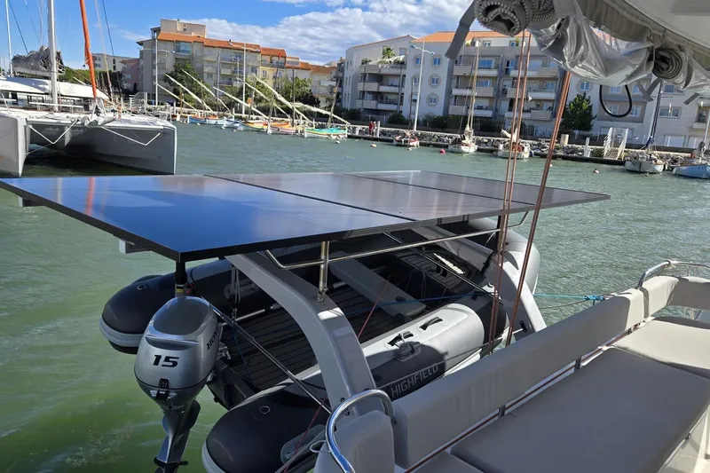  Yacht Photos Pics Excess 14 catamaran with solar panels and outboard motor in marina, 2025 model.
