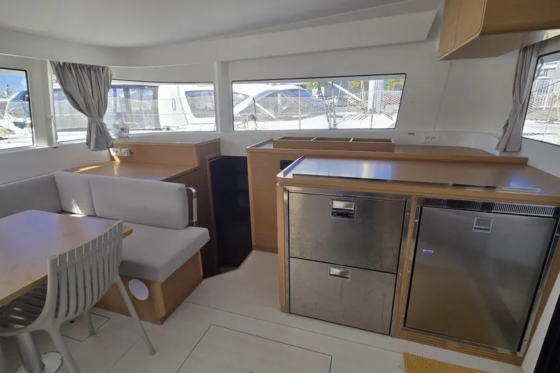  Yacht Photos Pics Modern interior of 2025 Excess 14 catamaran with dining area and kitchen.