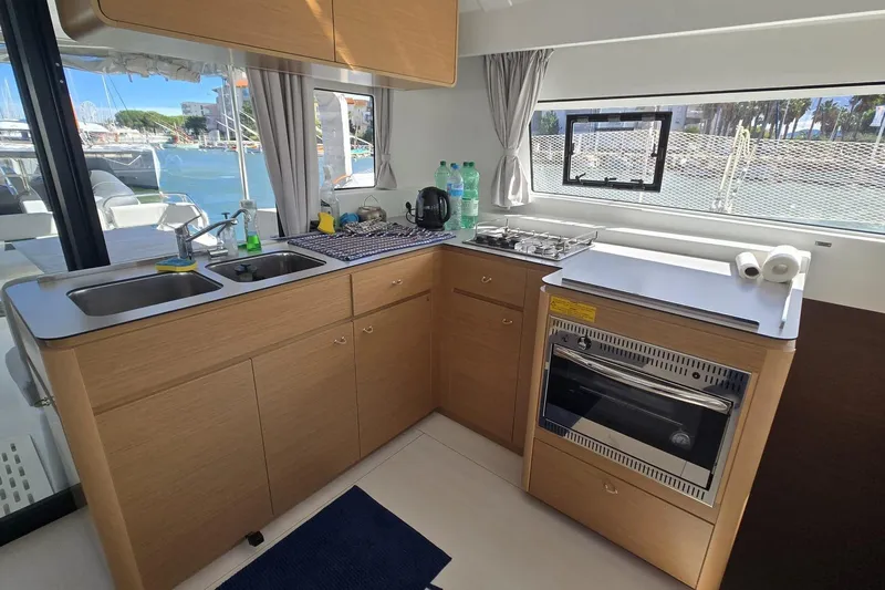  Yacht Photos Pics Modern kitchen in 2025 Excess 14 yacht with stove, sink, and scenic marina view.